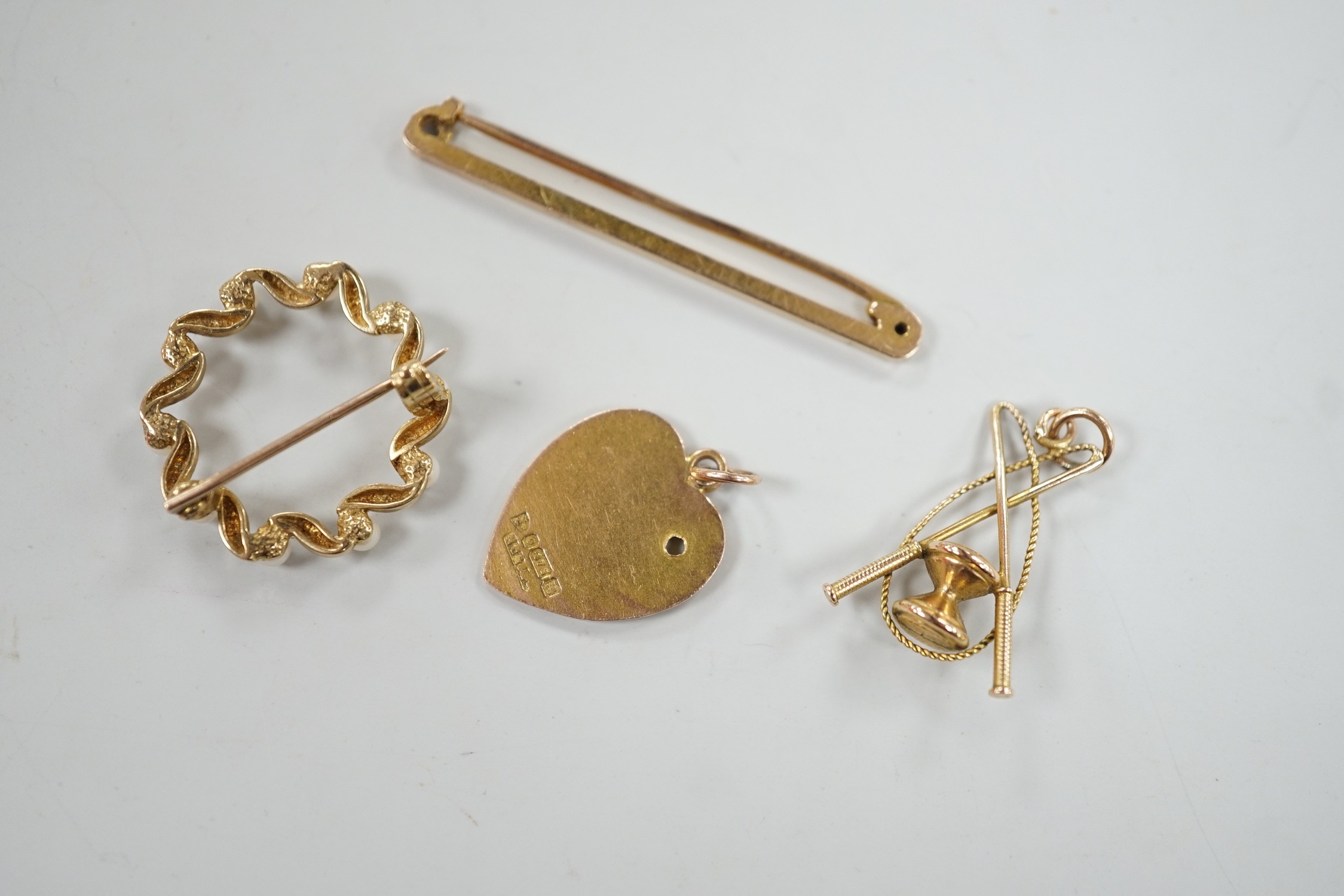 An Edwardian 9ct gold heart pendant (stone missing), 18mm, a yellow metal diablo charm and two brooches including 9ct bar brooch, gross weight 8.1 grams.